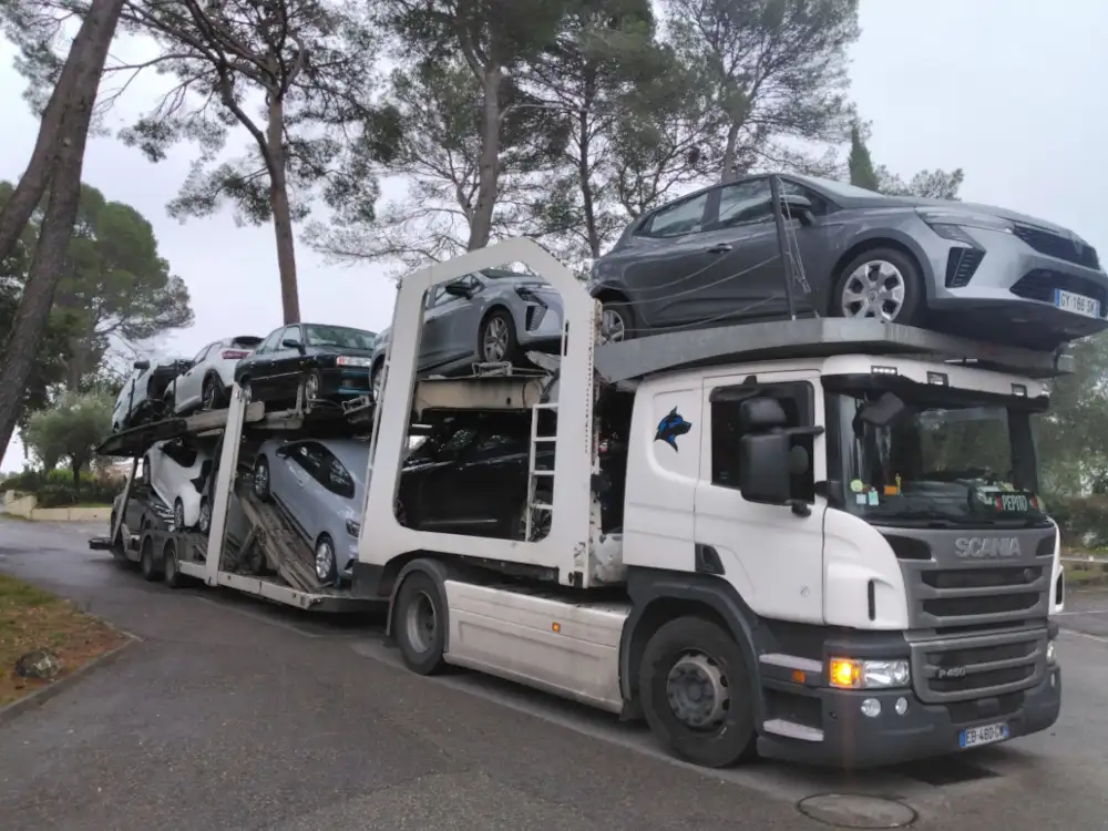 Camion porte-voitures OLIREM chargé, sous les pins