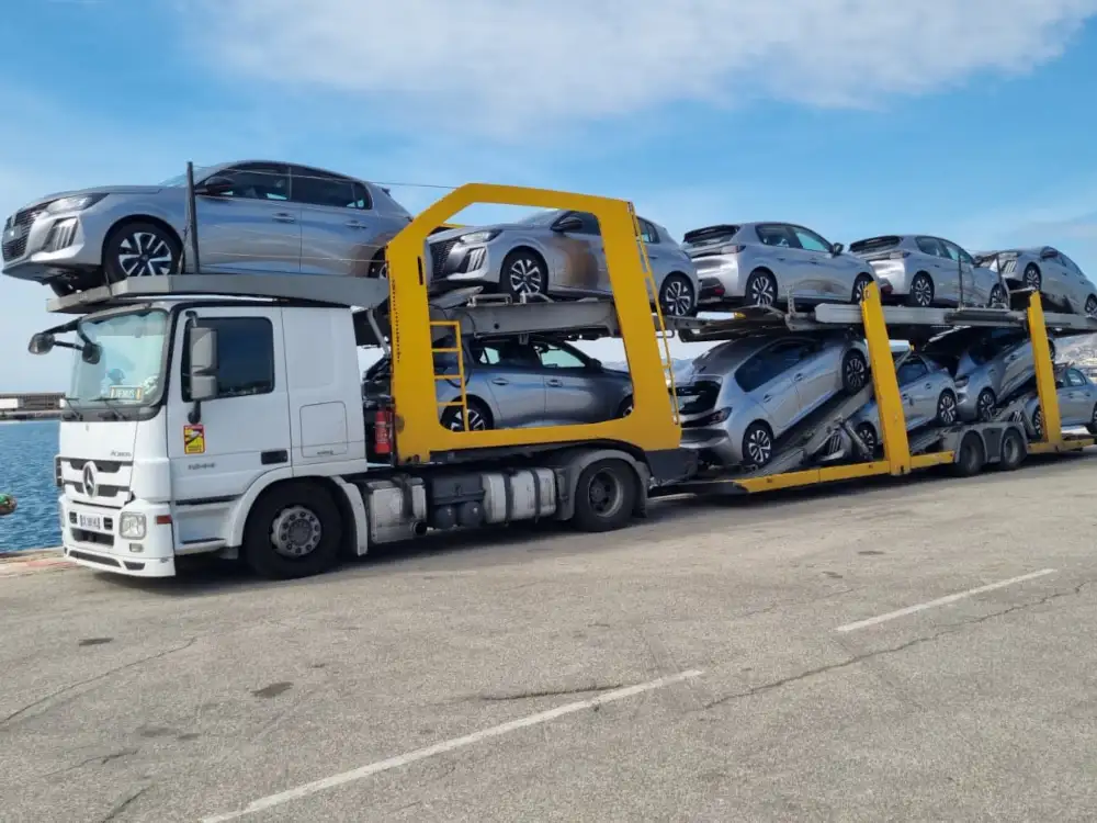 Camion porte-voitures OLIREM chargé de voitures neuves, sur un quai